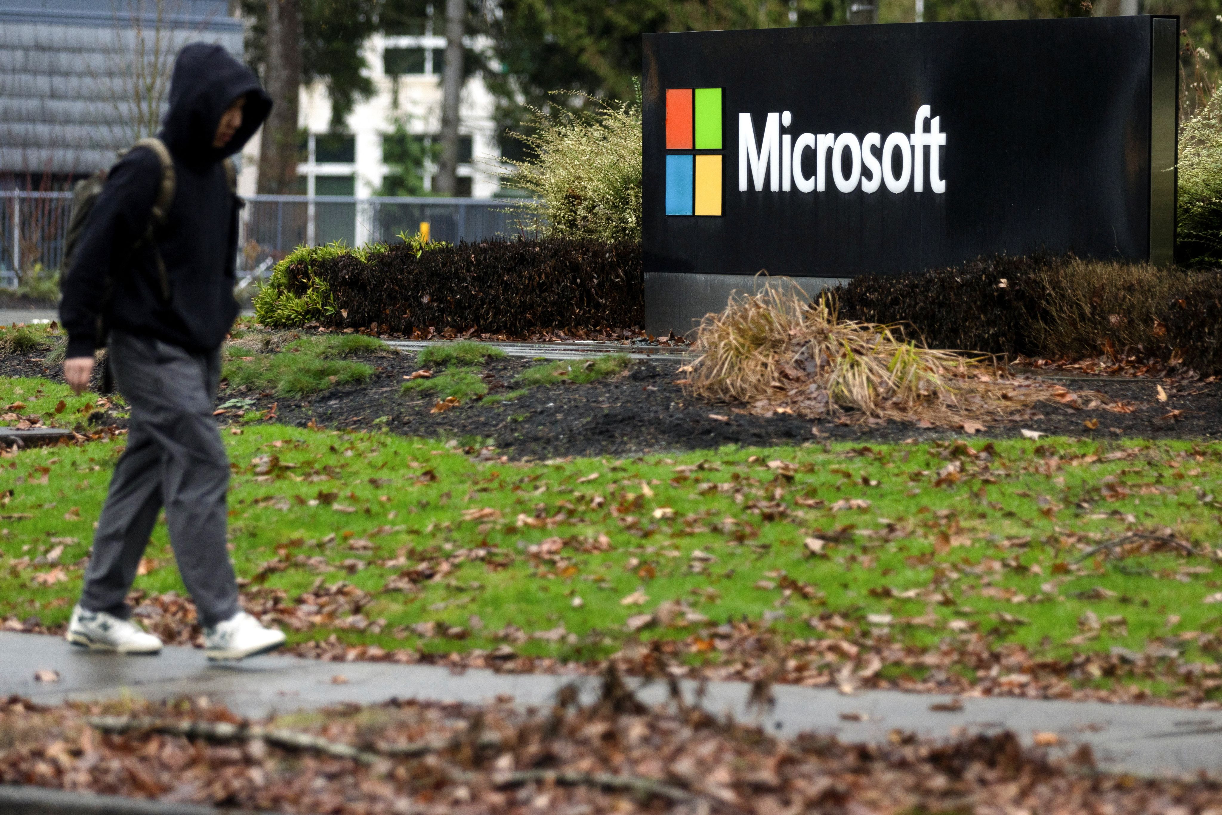 A person walks past Microsoft signage at the headquarters in Redmond, Washington. Credit: Reuters File Photo