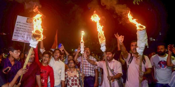 Junior doctors raise slogans during a torch rally towards the CBI office in protest against the alleged rape and murder of a woman medic at the RG Kar Medical College and Hospital, in Kolkata. Credit: PTI Photo